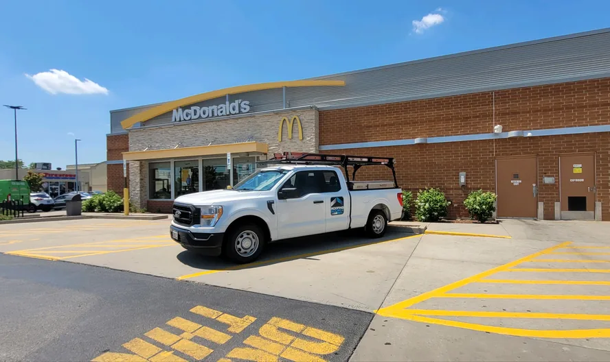 A RoofingSource pickup parked outside a McDonald’s restaurant