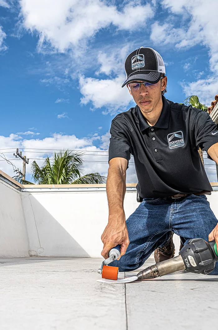 A RoofingSource teammate marking out work on a flat roof
