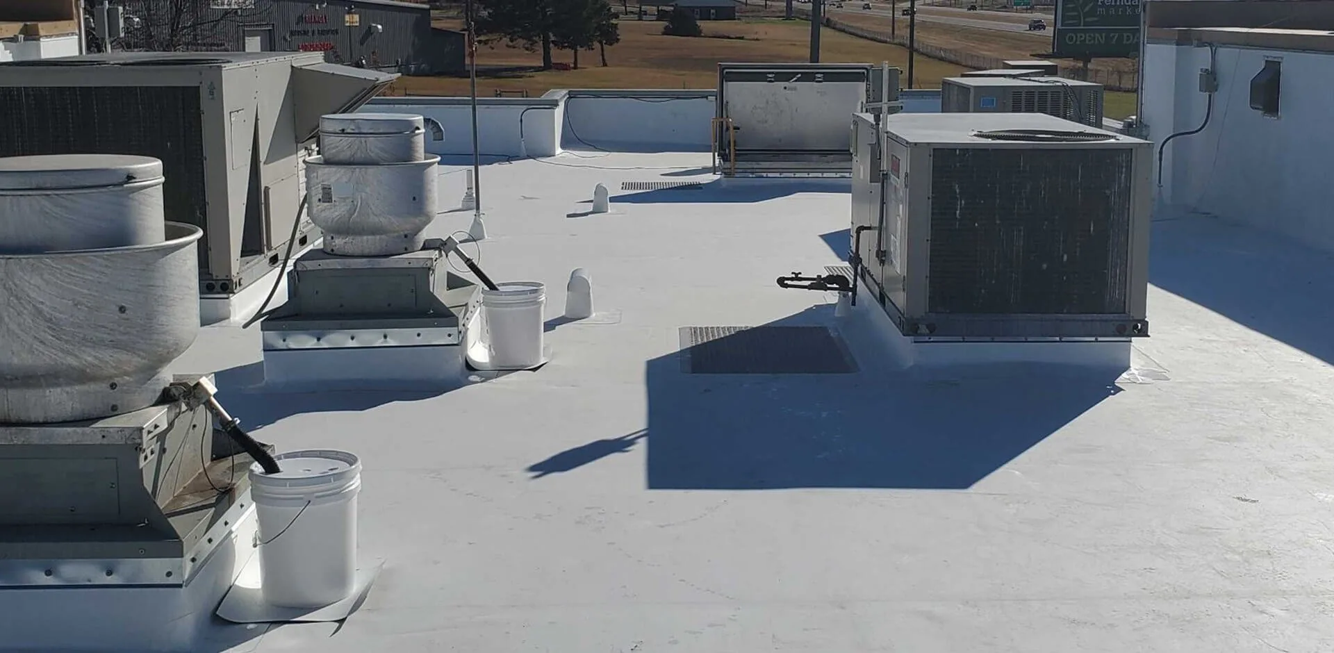 A commercial roof under a new white membrane, its rooftop units in place