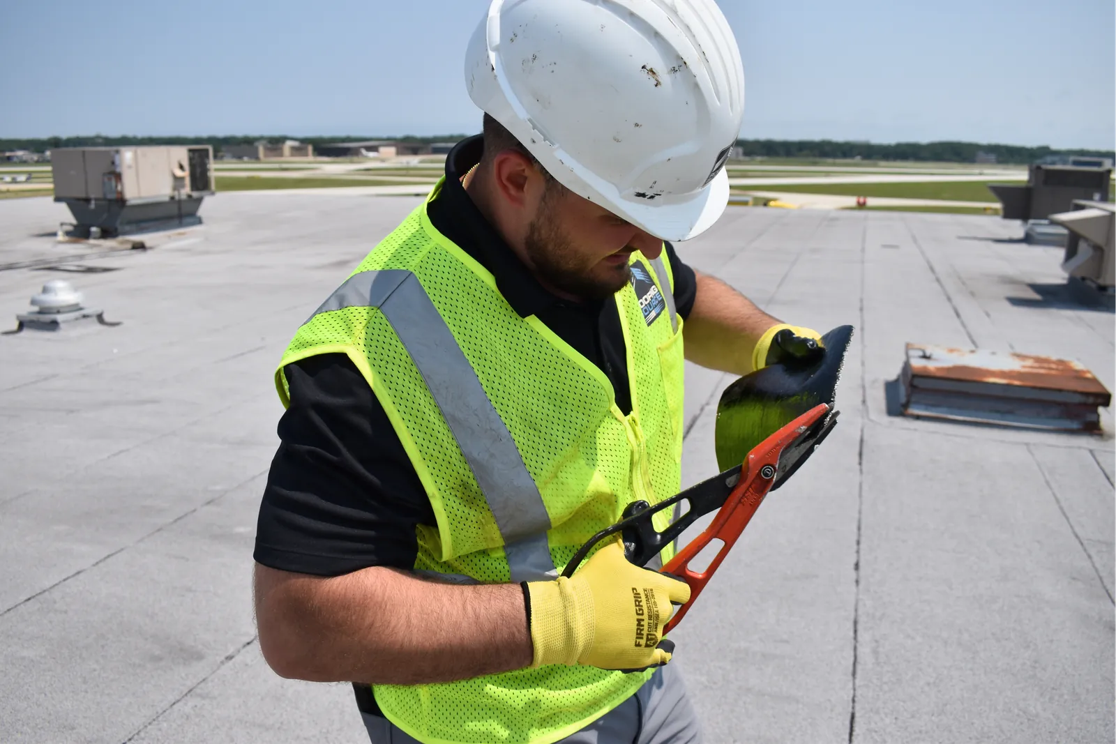 A Field Advisor working with a tool on a roof seam
